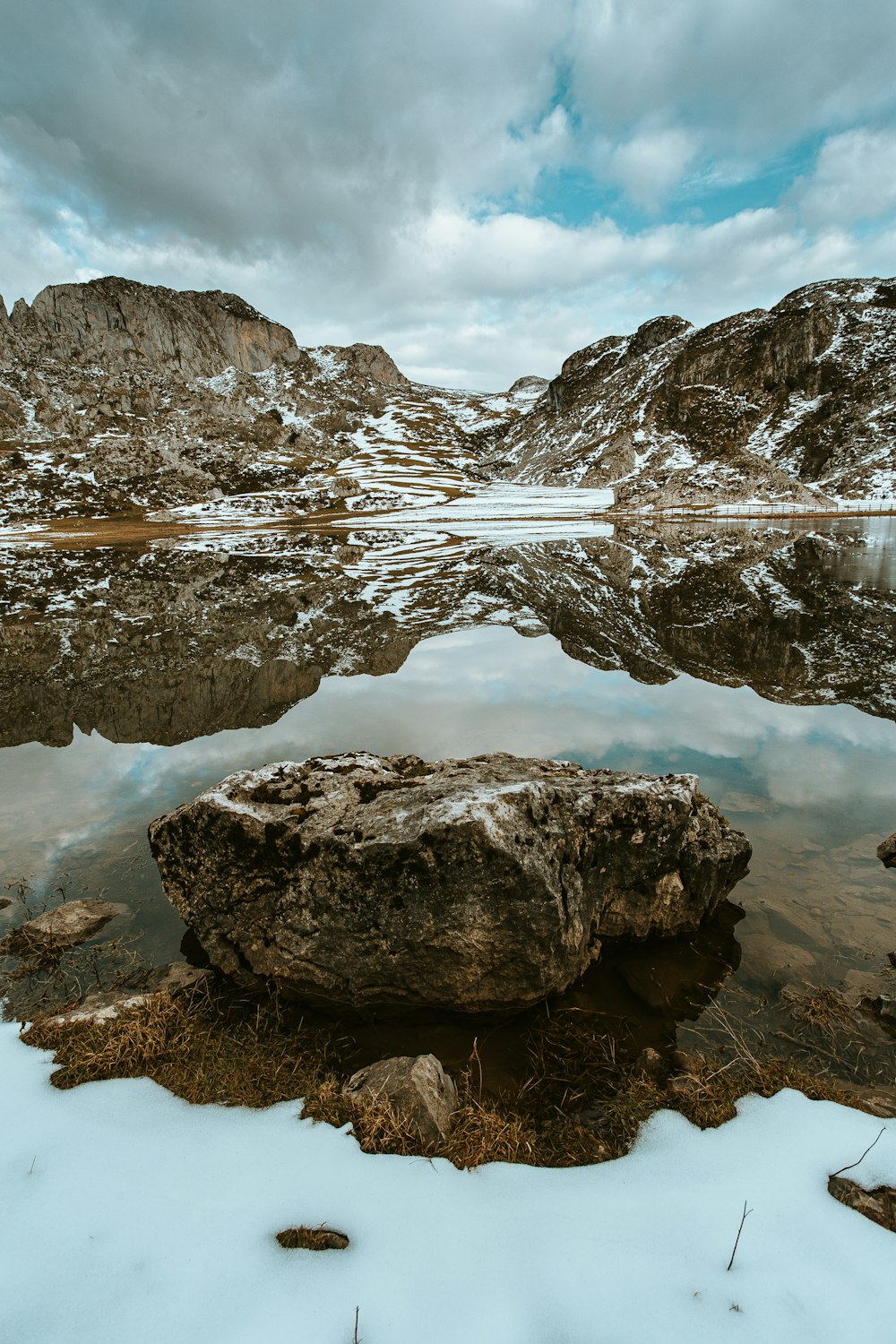 brown rocky mountain near lake during daytime