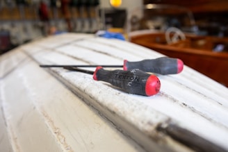 black and red hand tool on white table