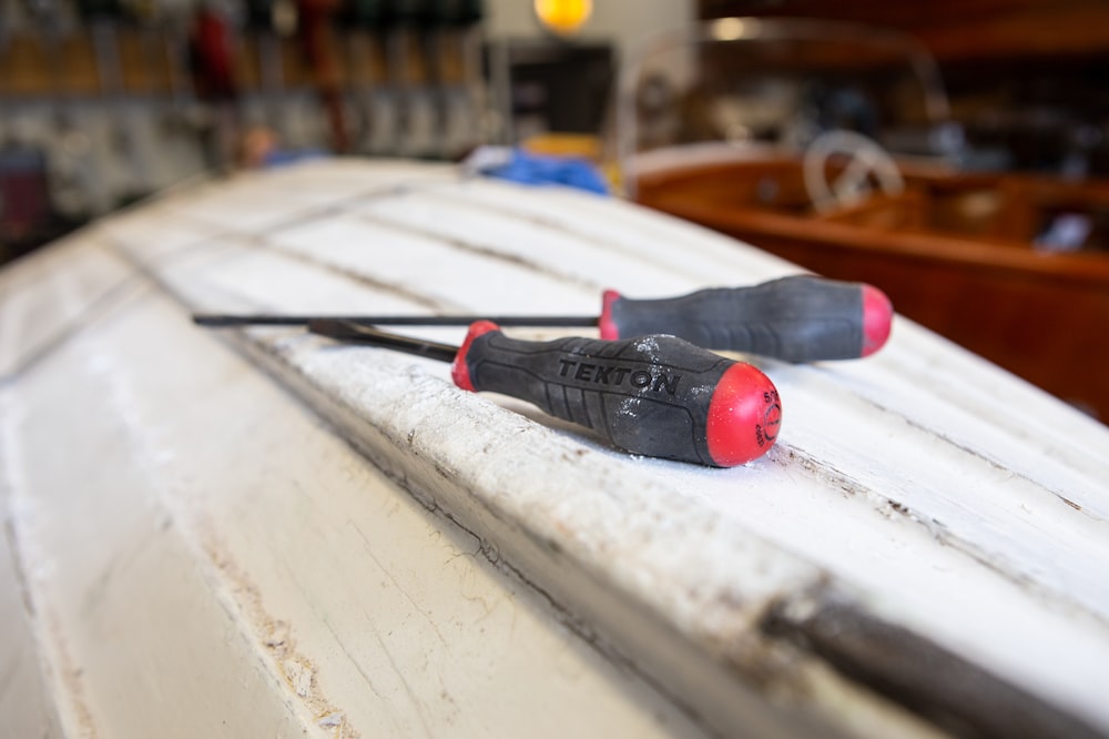 black and red hand tool on white table