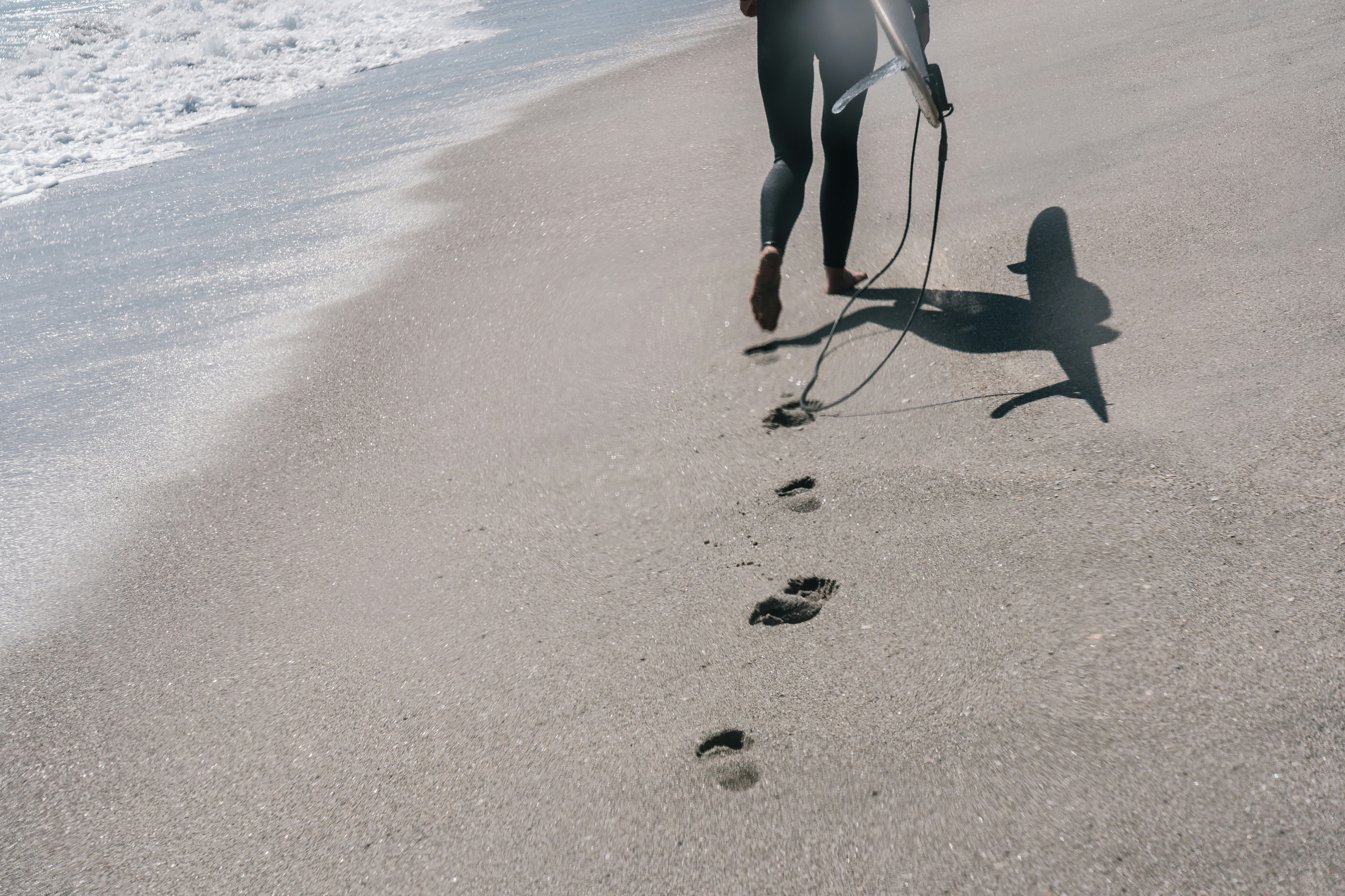 woman in white bikini walking on beach during daytime