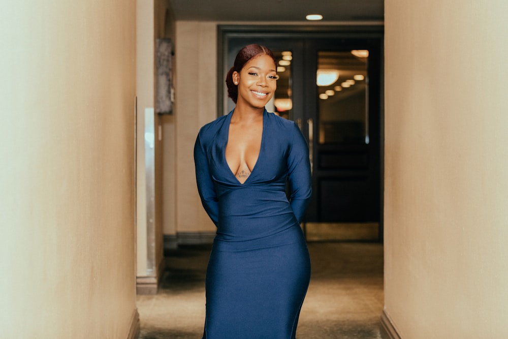 woman in blue v neck long sleeve dress standing on hallway