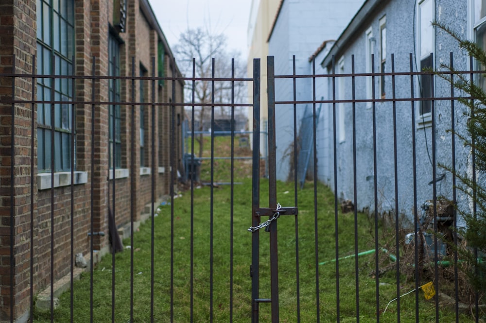 grey metal fence near brown wooden house during daytime