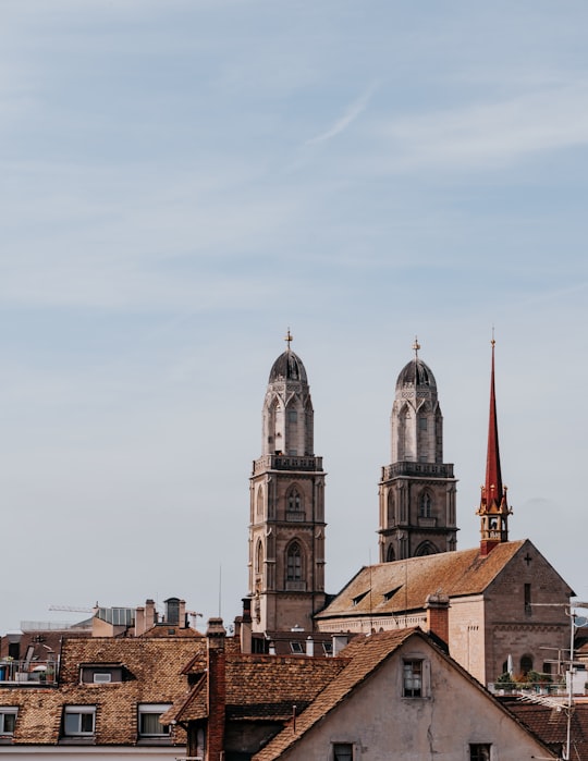 brown and white concrete building under white sky during daytime in Grossmünster Switzerland