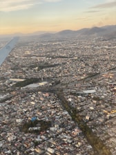Drone view capturing the skyline of Bogotá with luxury buildings and green spaces at sunset.