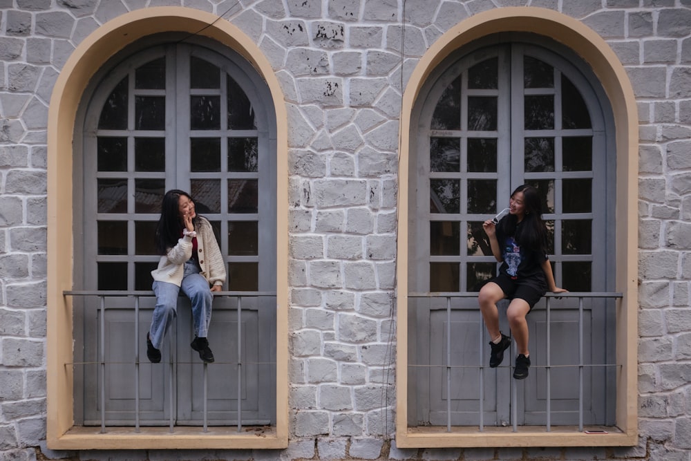 2 femmes assises sur la fenêtre