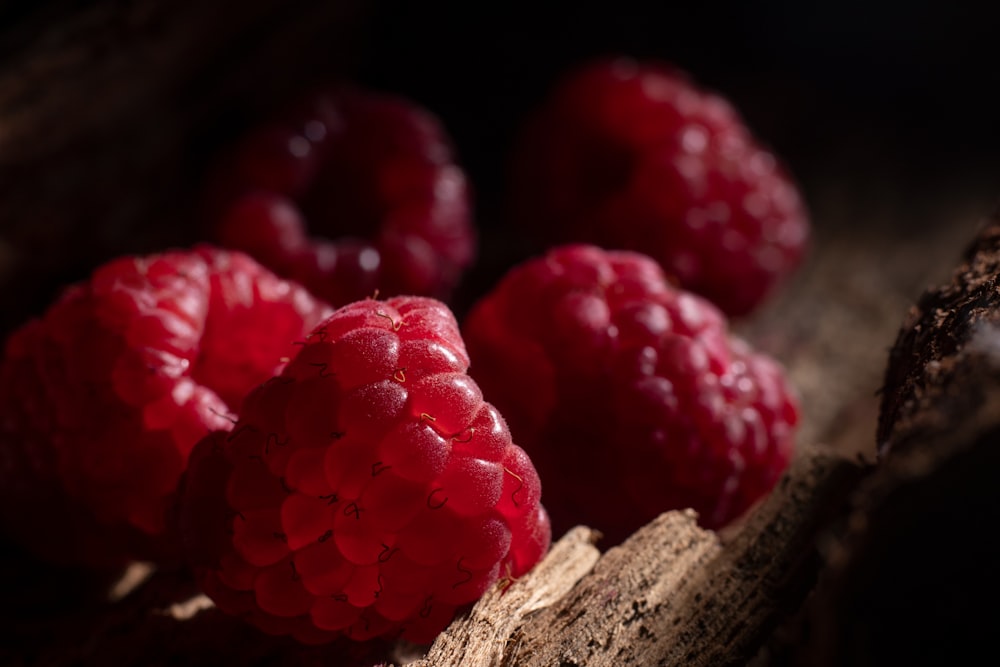 red raspberries on brown wooden surface