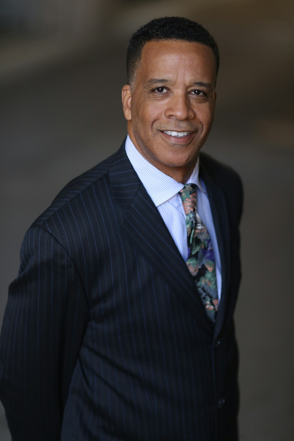 man in black and white pinstripe suit jacket smiling