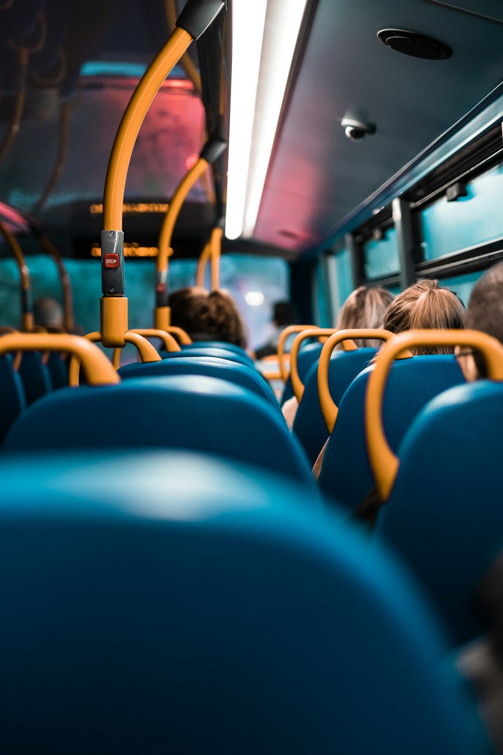 pessoas sentadas em assentos de ônibus azuis e amarelos
