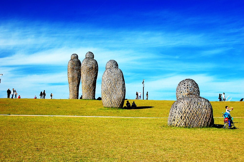 gray stone formation on green grass field under blue sky during daytime