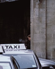 man in black jacket standing beside car during daytime