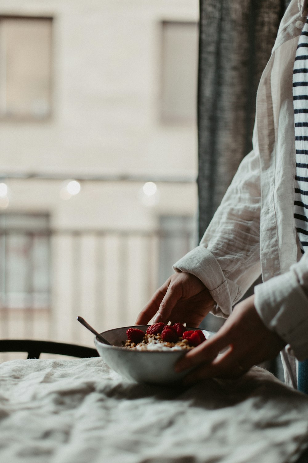 person holding red and white ceramic bowl