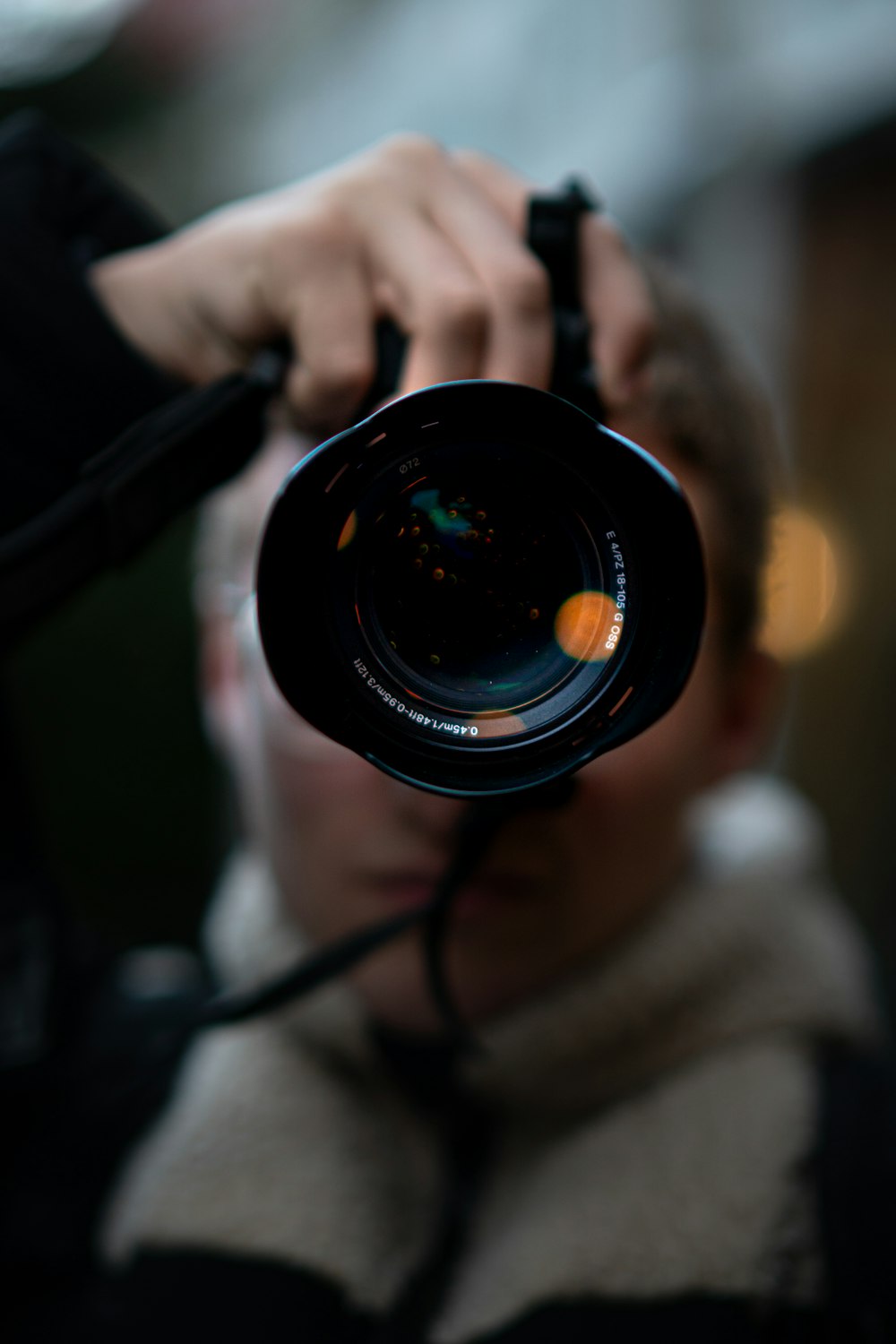 person holding black camera lens