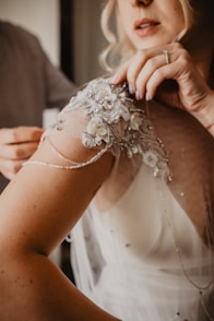 woman in white floral lace dress holding mans hand
