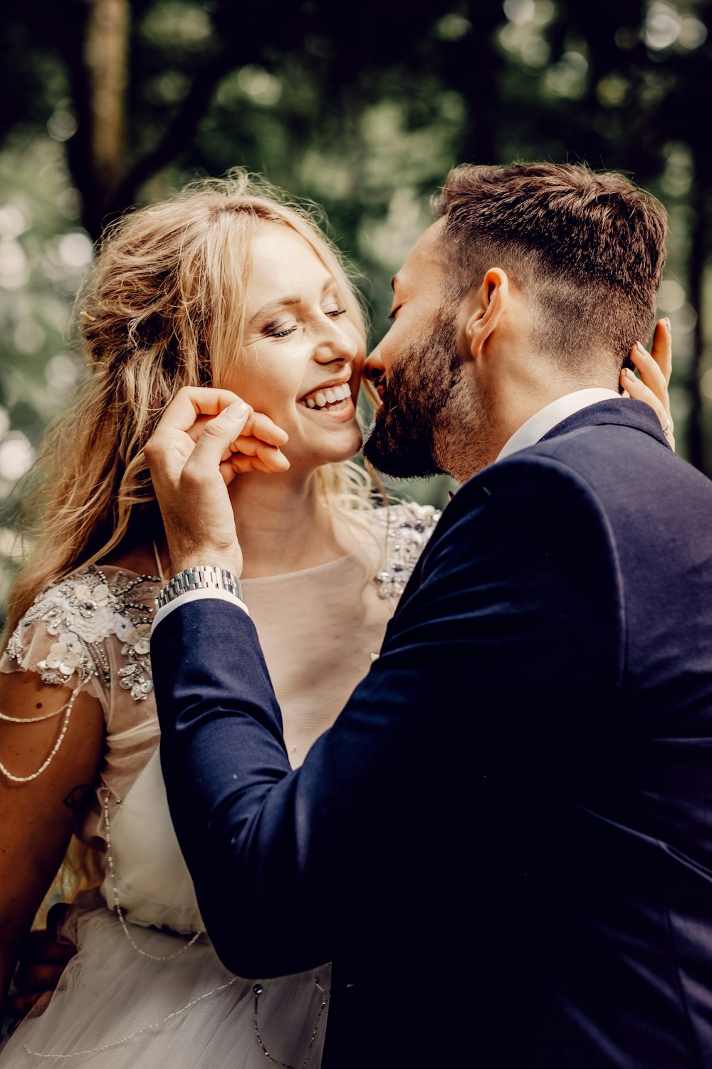 man in black suit kissing woman in white floral dress