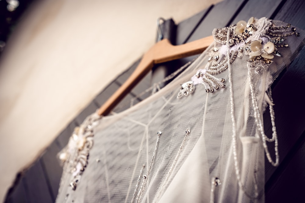 white and gray textile on brown wooden clothes hanger