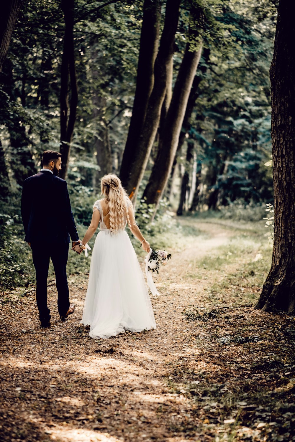 man and woman walking on forest during daytime