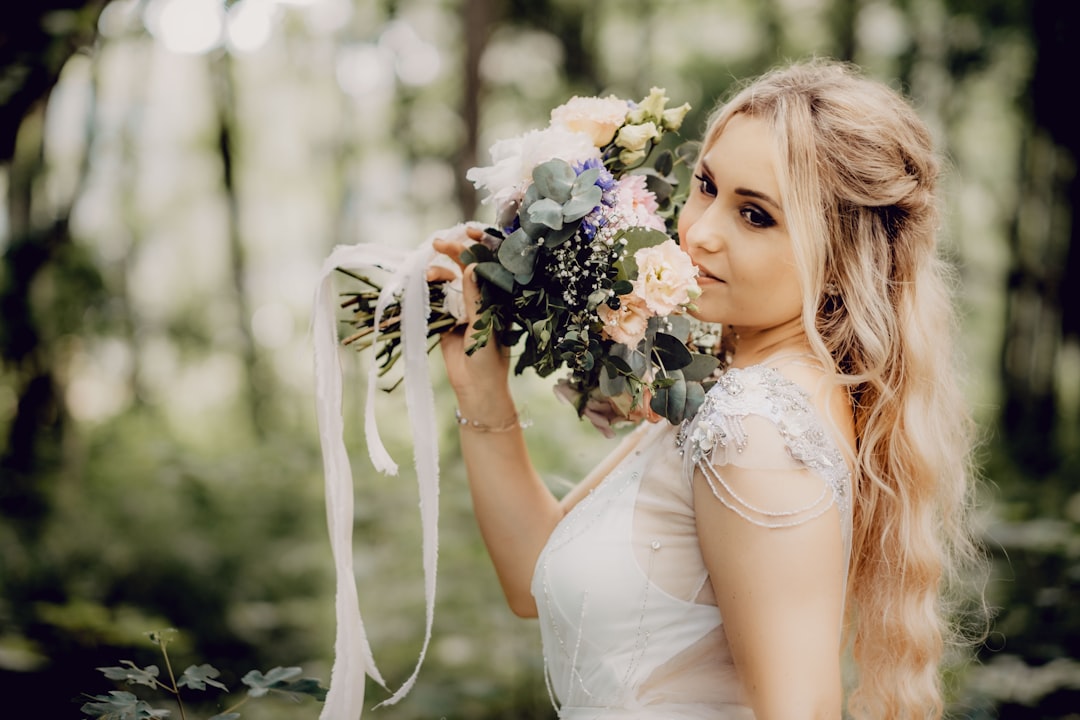 woman in white dress holding bouquet of flowers