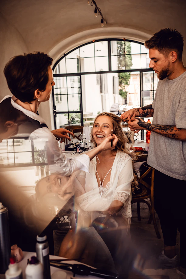 A warm, inviting consultation scene with a stylist and a woman exploring color palettes and outfit options.