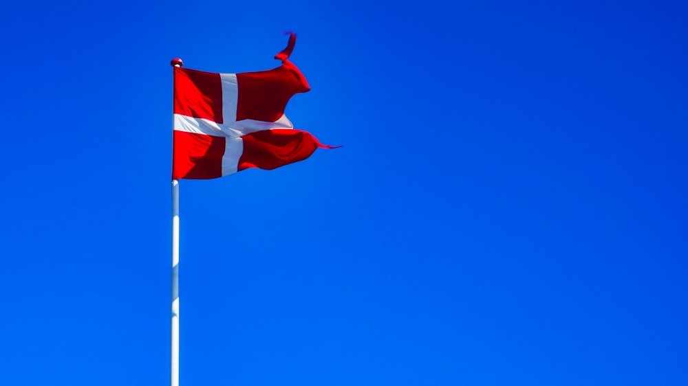 red and white flag under blue sky during daytime