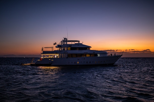 white ship on sea during sunset