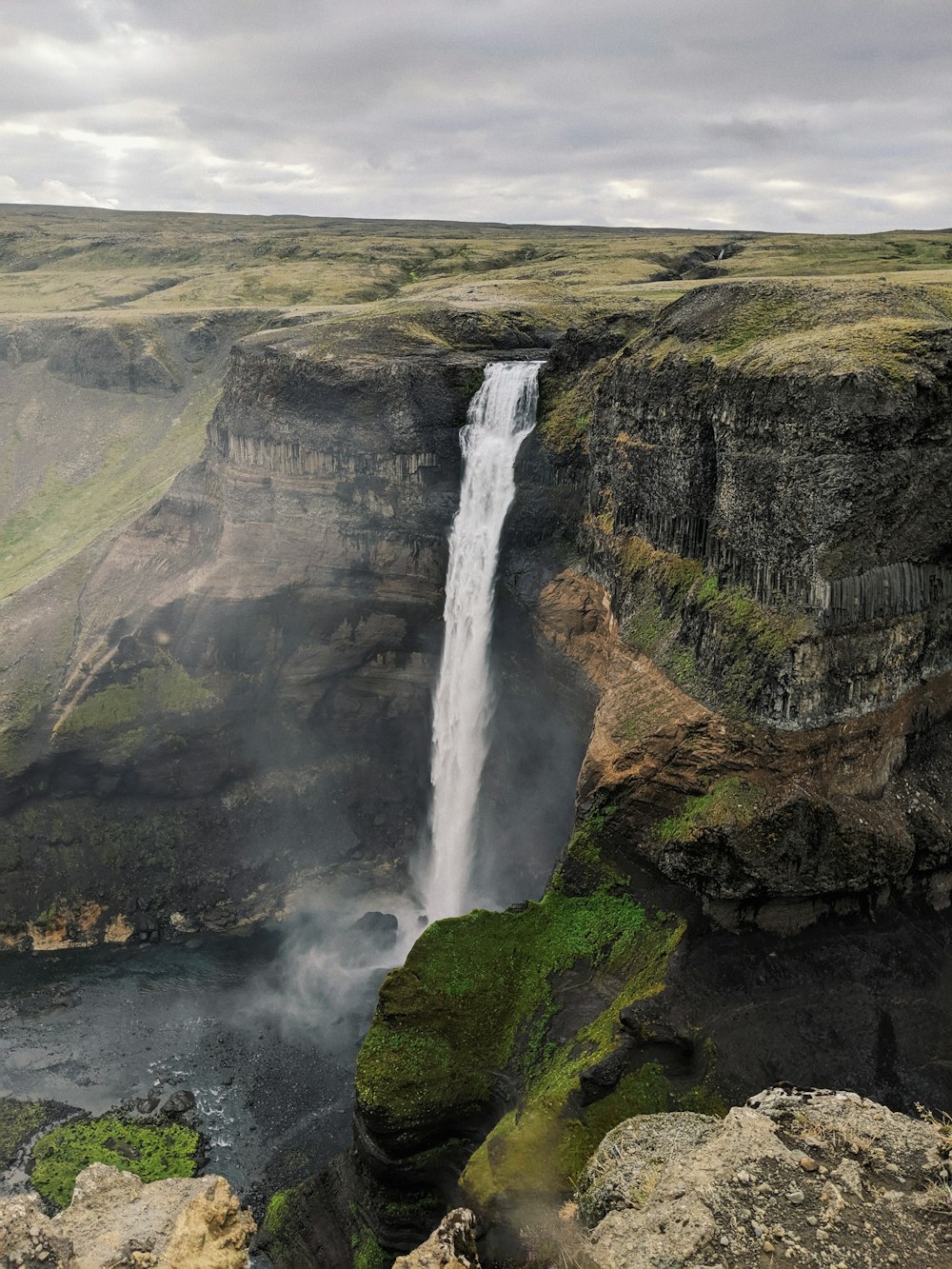 waterfalls on brown and green mountain during daytime