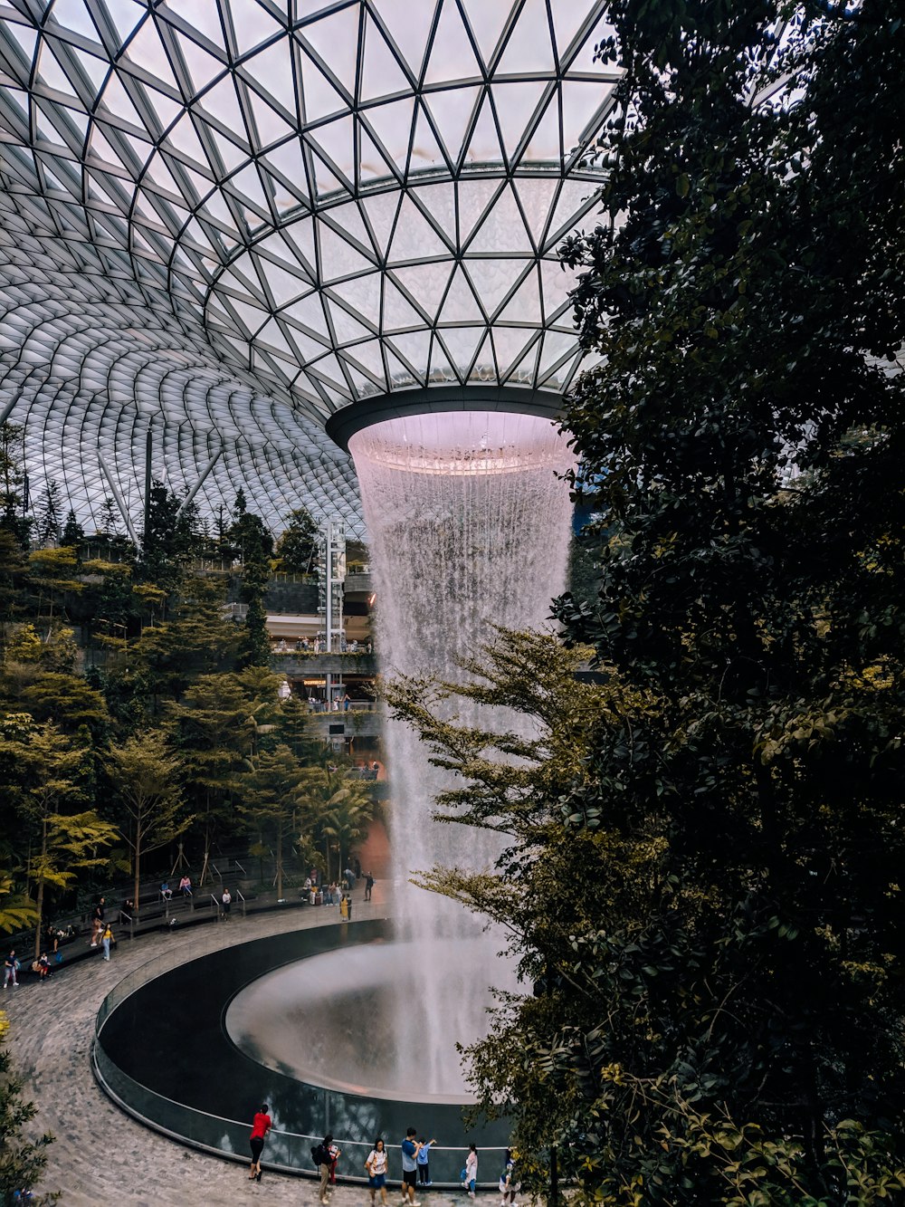 water fountain near trees and building during daytime