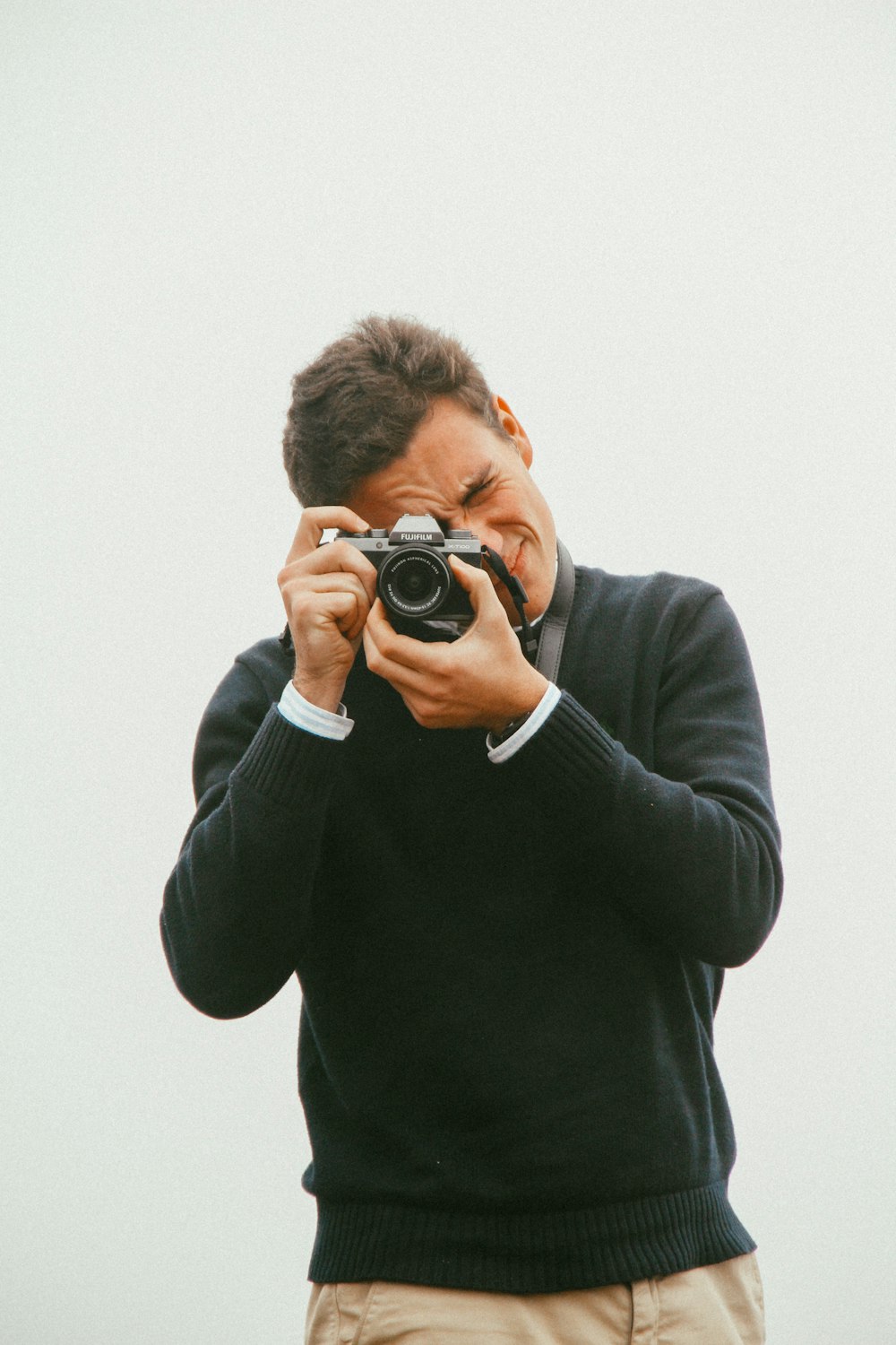 man in black long sleeve shirt holding black dslr camera