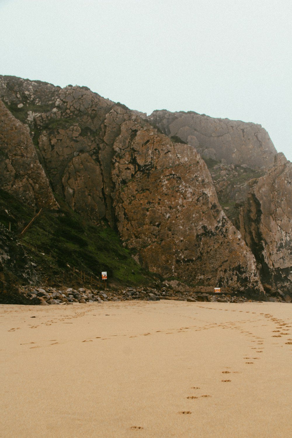 person walking on beach near mountain during daytime