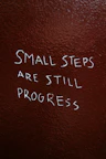 Small steps are still progress written on brown background