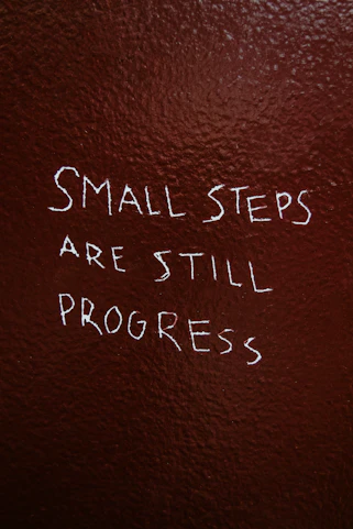 Small steps are still progress written on brown background