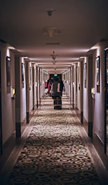 person in black jacket walking on hallway