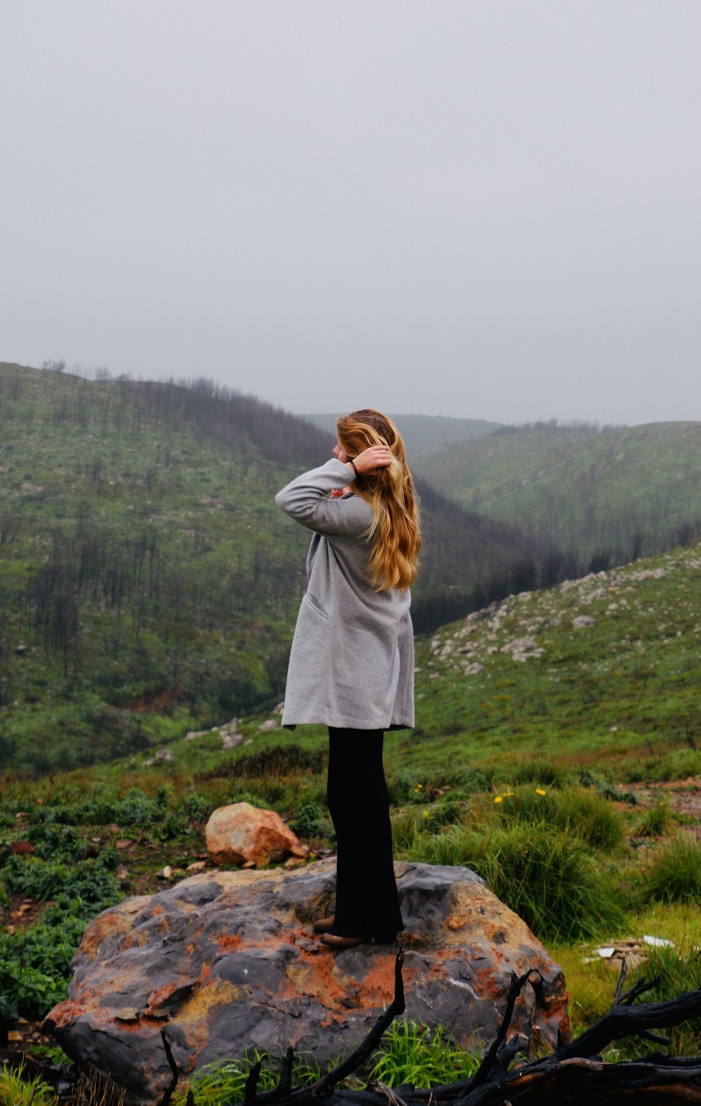 woman in gray jacket standing on green grass field during daytime