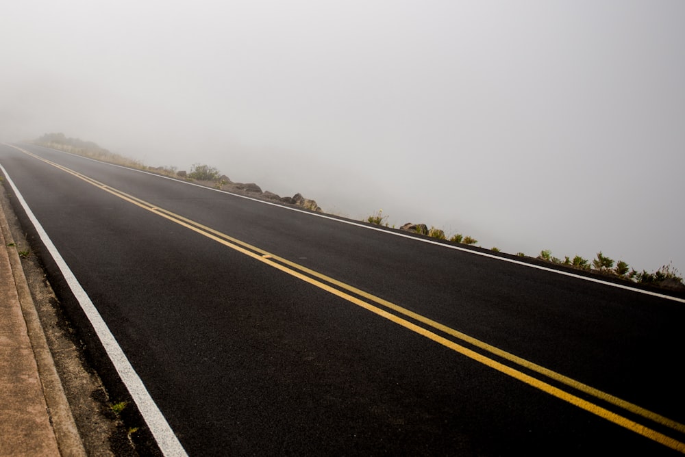 route goudronnée noire pendant la journée