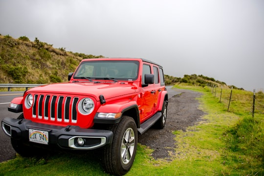 red jeep wrangler on green grass field during daytime in Haleakalā National Park United States