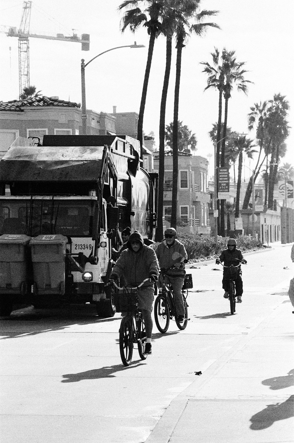 grayscale photo of people riding bicycle on street