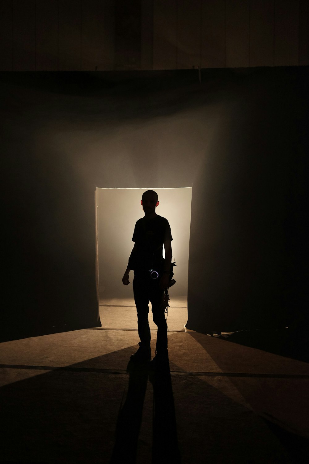 a person standing in a dark room with a motorcycle