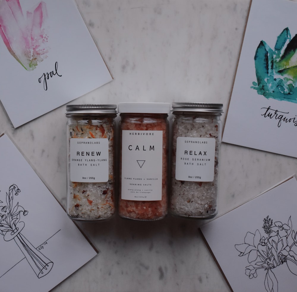 three clear glass jars on white floral table