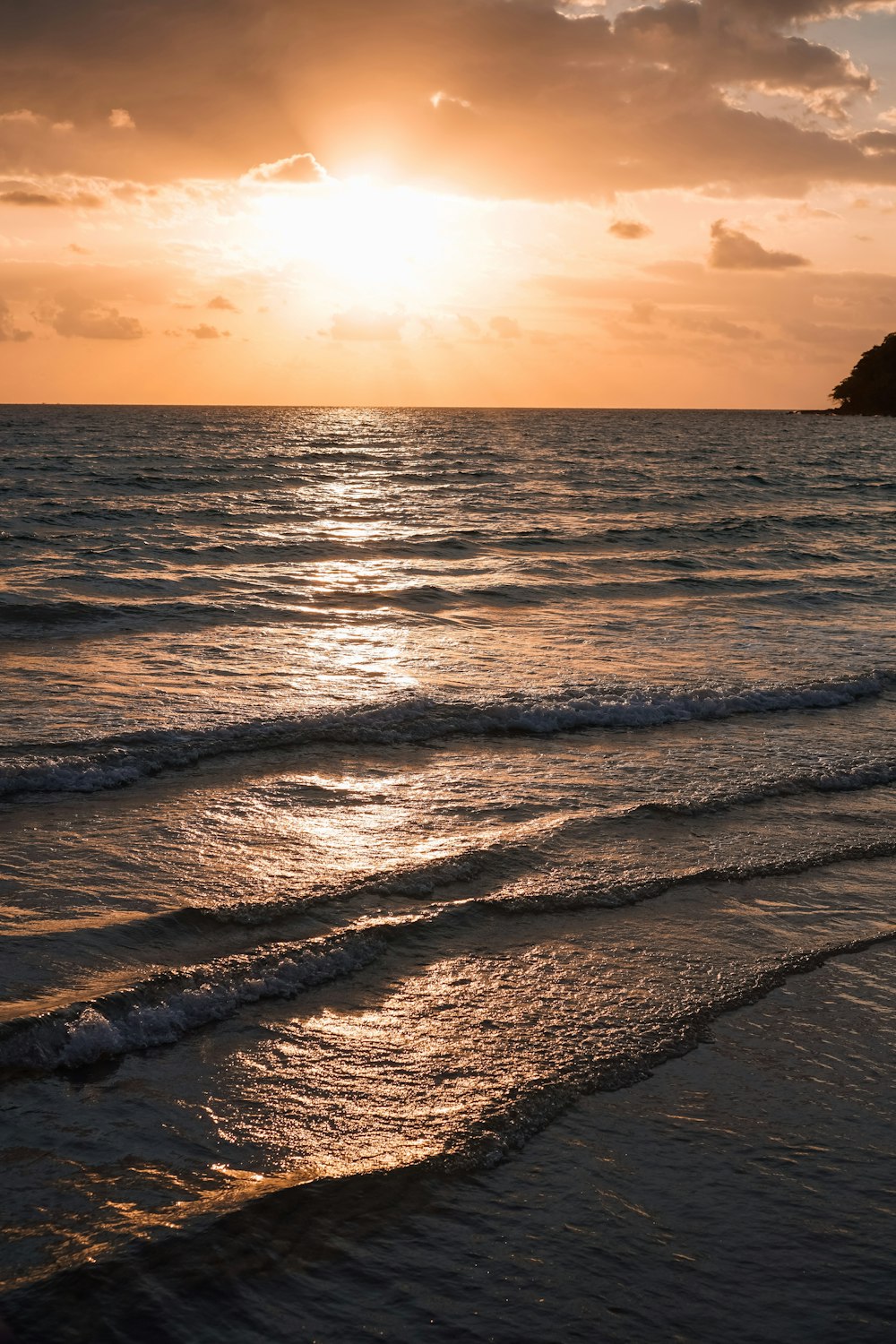 sea waves crashing on shore during sunset