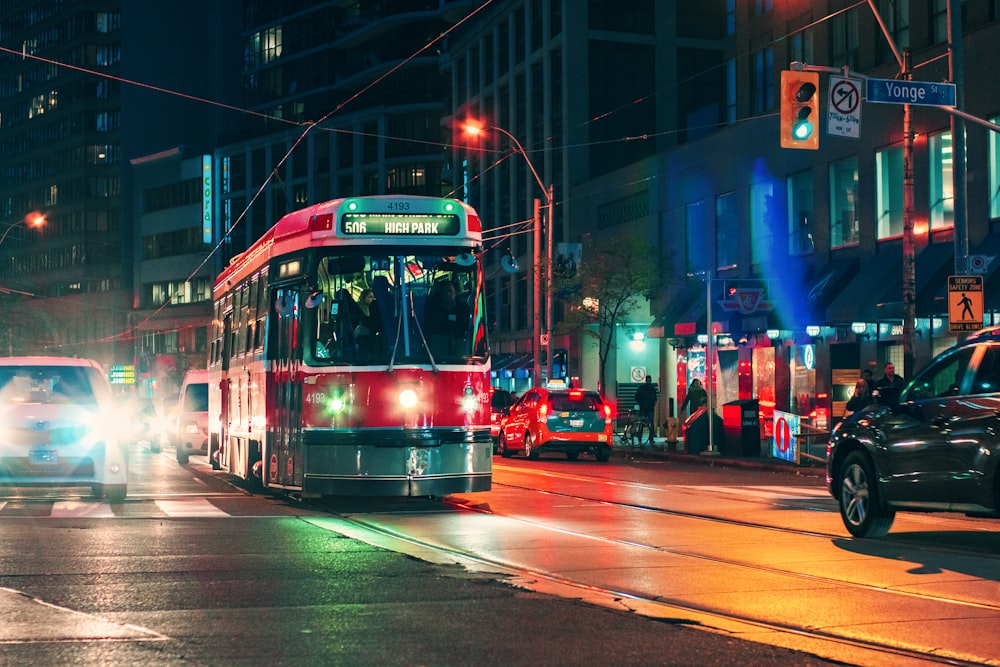 red and white tram on road during nighttime