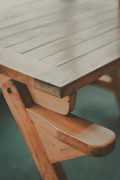 Close-up of a handcrafted wooden dining table with natural stone inlay under warm lighting