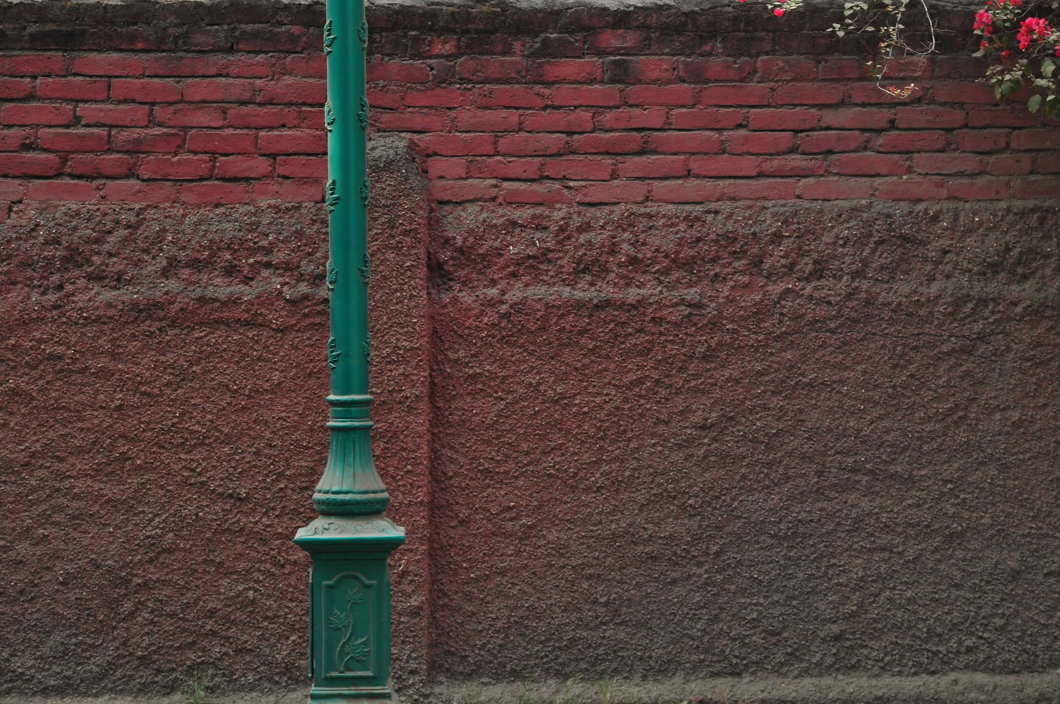 blue metal post beside brown brick wall