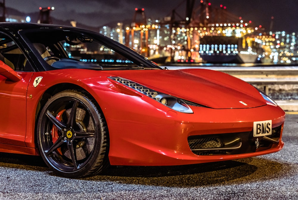red ferrari 458 italia parked near white and brown building during night time
