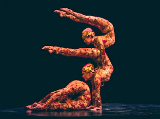 Sofie Dossi performing an impressive contortion pose on stage with vibrant lighting.