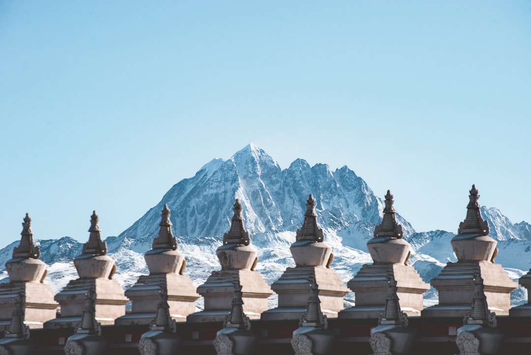 brown and white concrete building near mountain under blue sky during daytime