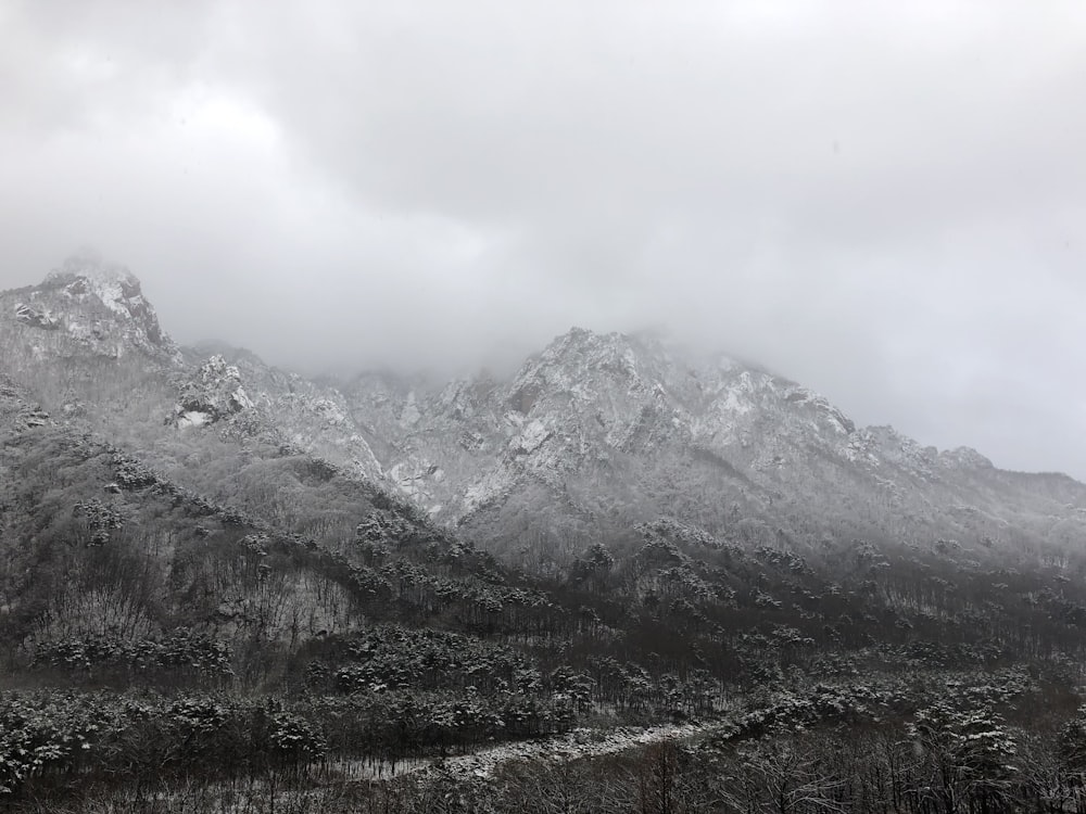 montanha coberta de neve sob céu nublado durante o dia