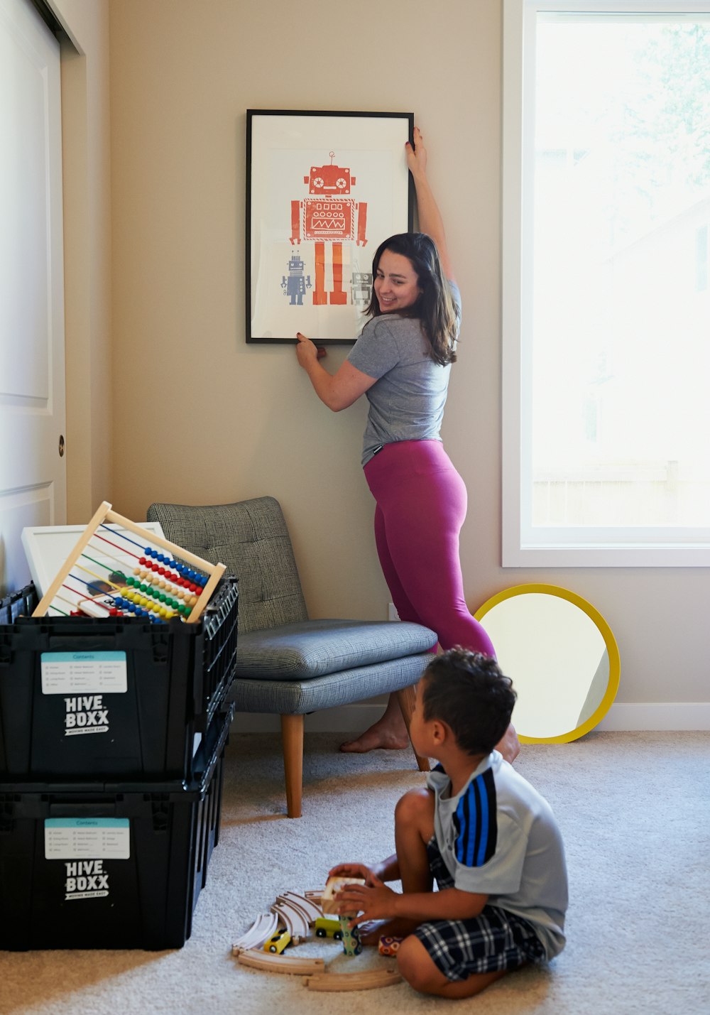 woman in gray shirt and pink pants sitting on gray chair