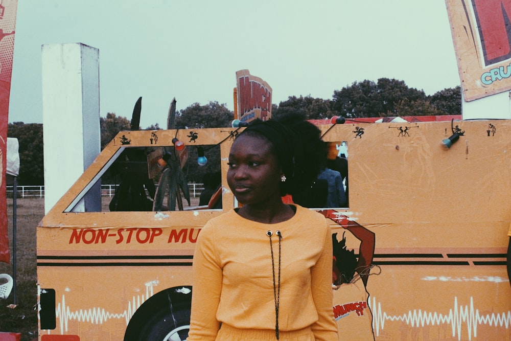 woman in yellow turtleneck sweater standing near brown building during daytime