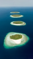 green and brown island in the middle of blue water