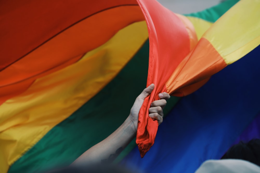 person holding orange yellow and blue flag