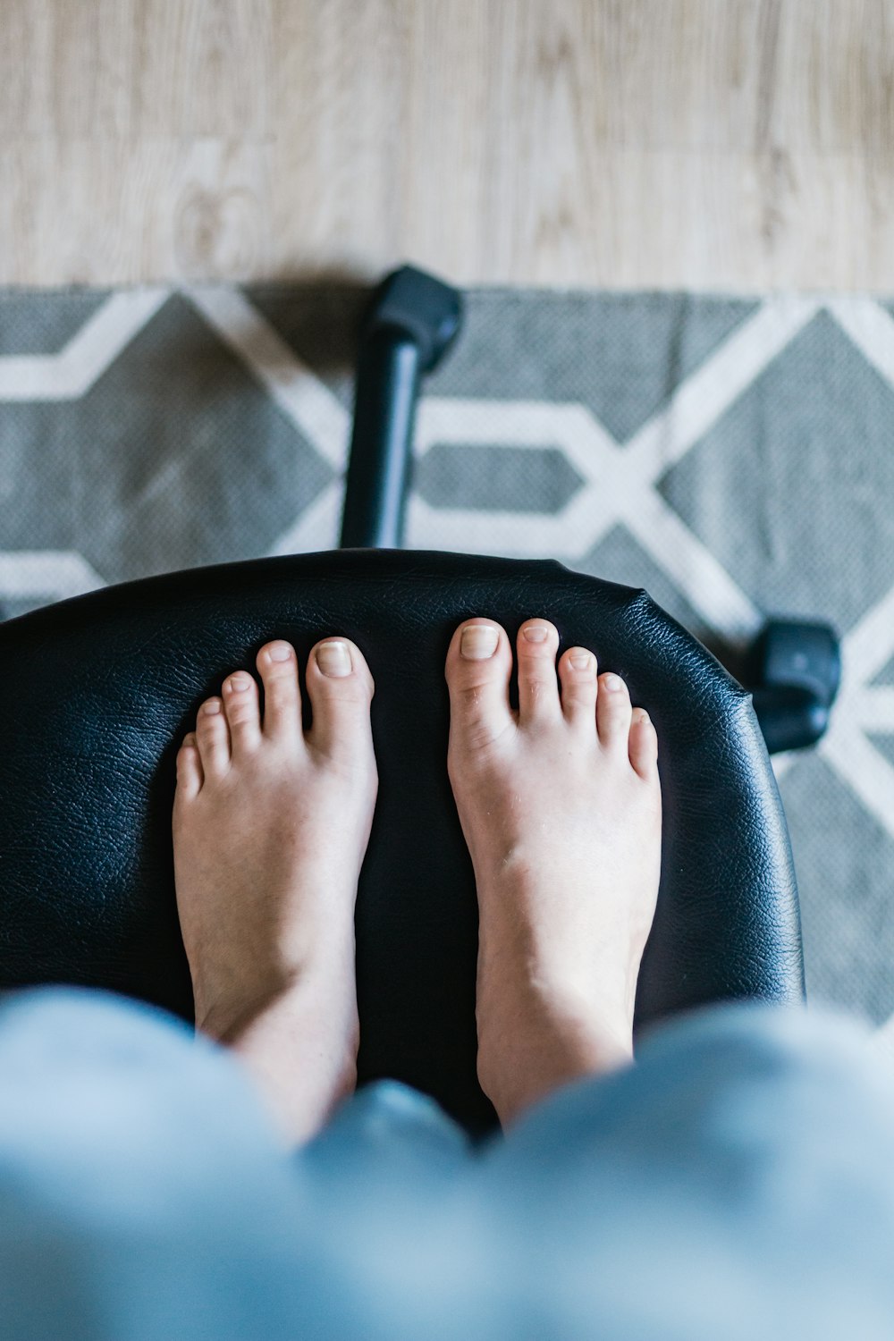 persons feet on black leather chair